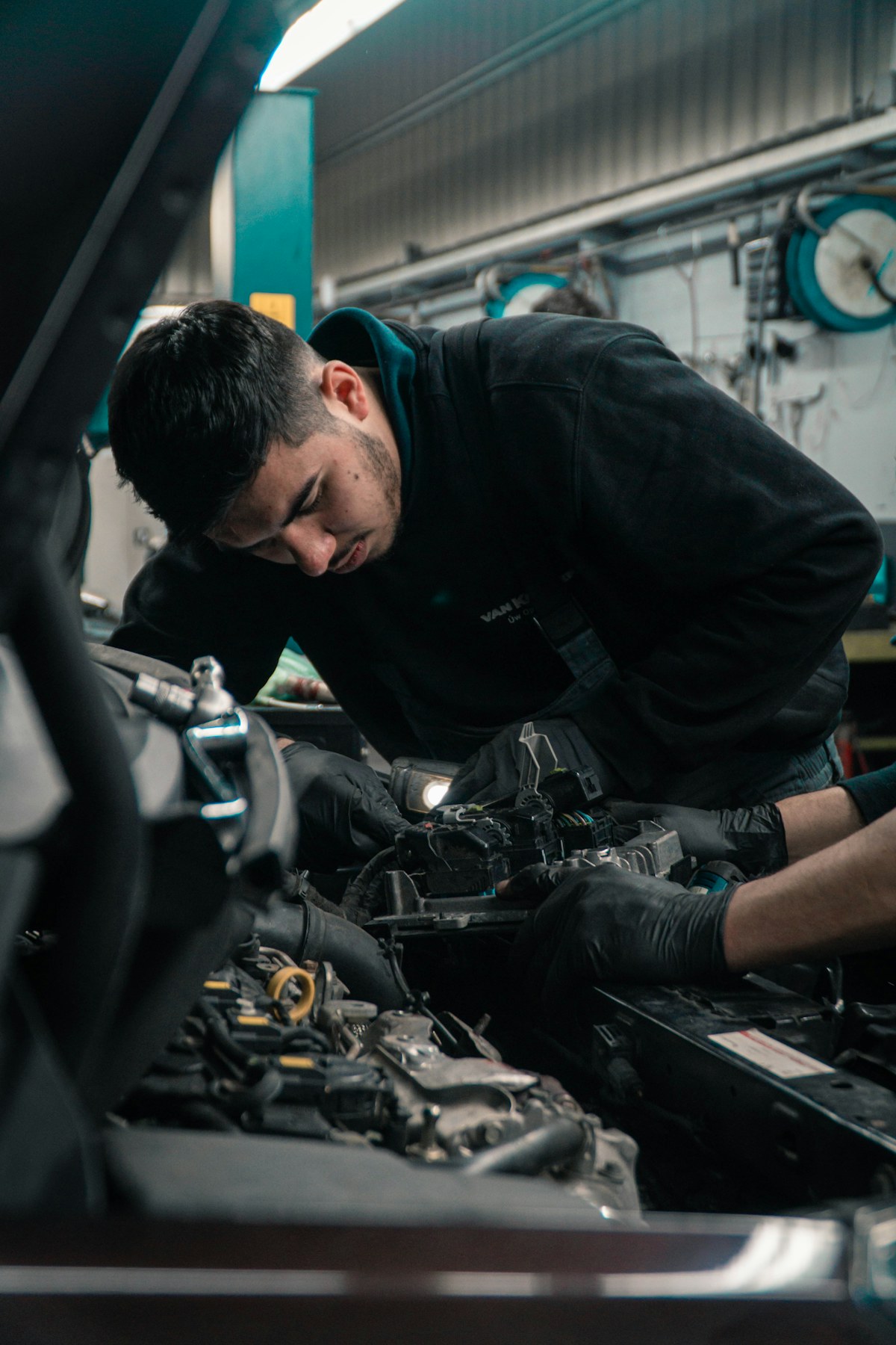 Mekanik memeriksa modul dan sistem kelistrikan mobil